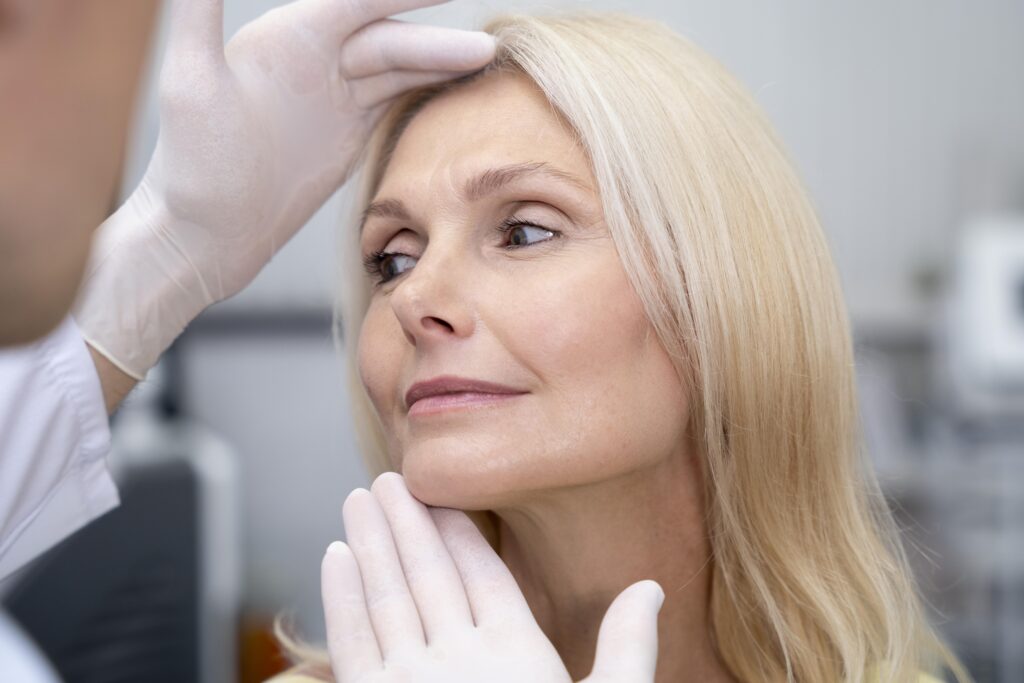 Mujer durante una valoración facial en consulta de medicina estética, imagen relacionada con los tratamientos inductores de colágeno de la Dra. Mariam Oddone.